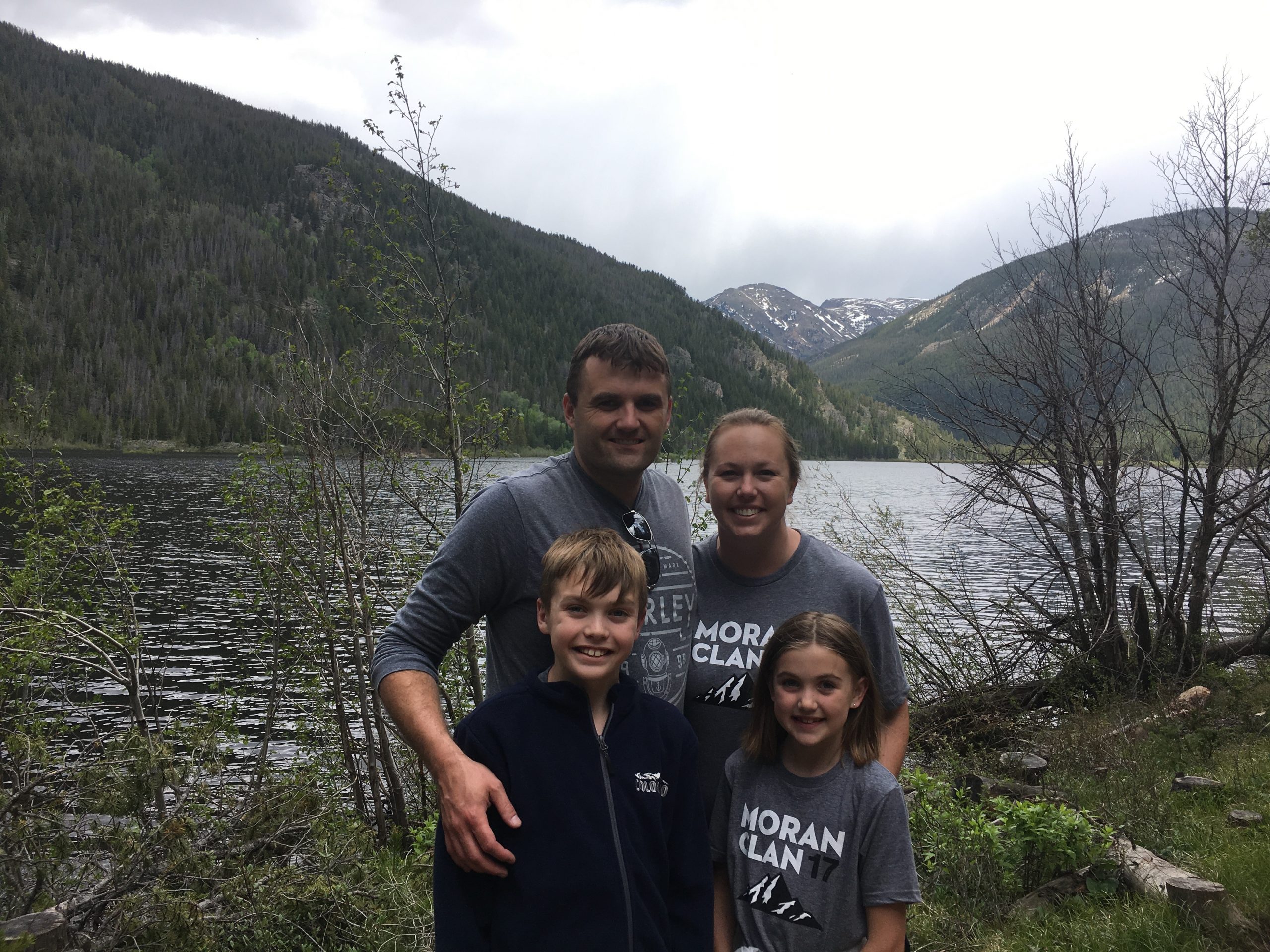 Family of four in front of lake and mountains