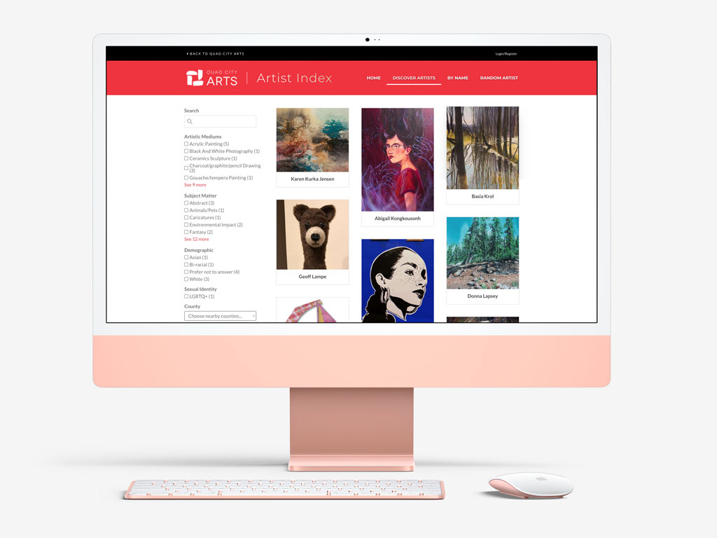 Pink iMac with an artist portfolio website shown on the screen.