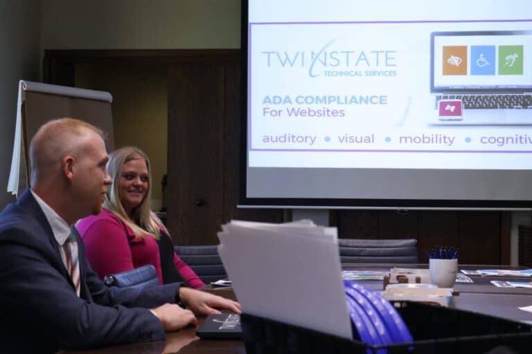 High-quality image of professionals attending a TST (Twin State Technical Services) compliance presentation on ADA website accessibility standards.