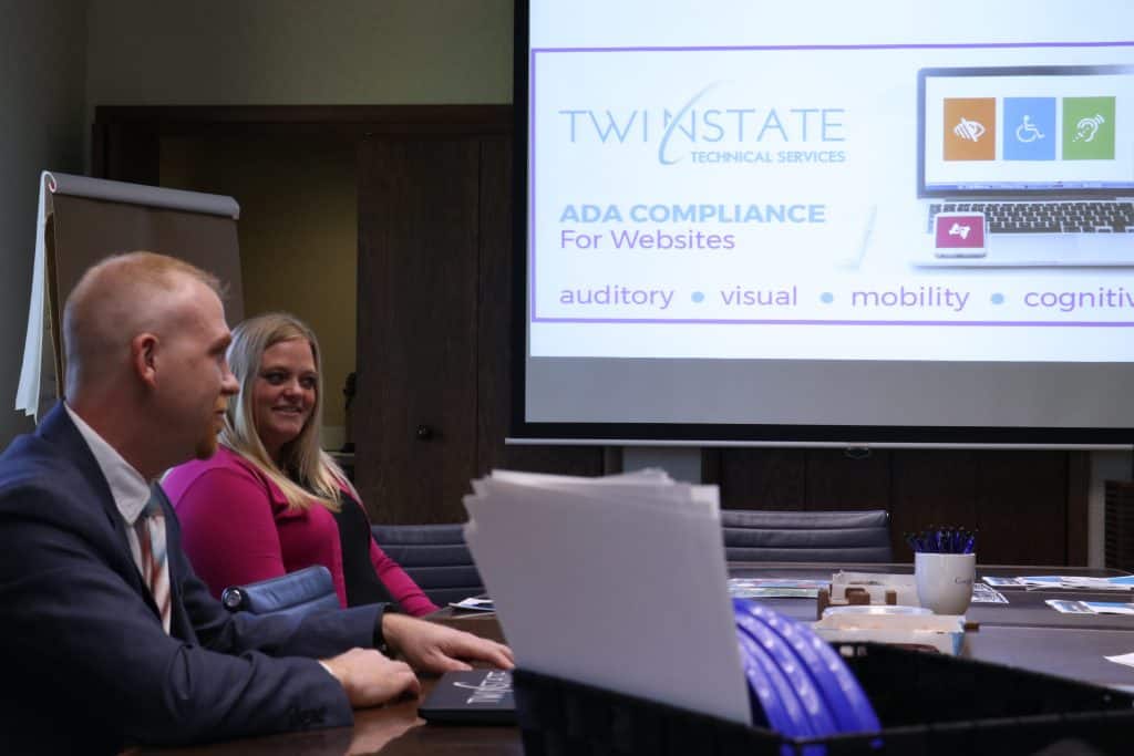 High-quality image of professionals attending a TST (Twin State Technical Services) compliance presentation on ADA website accessibility standards.