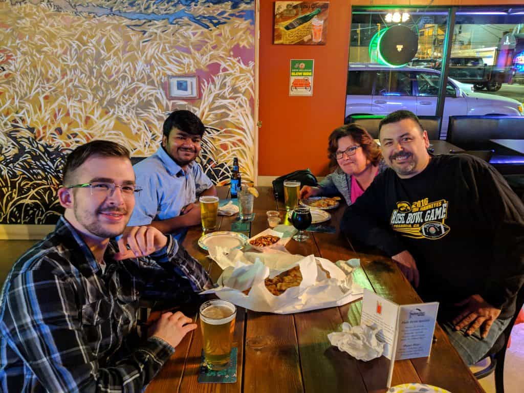 Twin State Technical Services team enjoying dinner at a restaurant with beverages and pizza, showcasing regional community and hospitality.