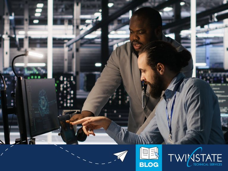 Two IT professionals collaborating on cybersecurity strategies in a data center environment with servers and monitors.